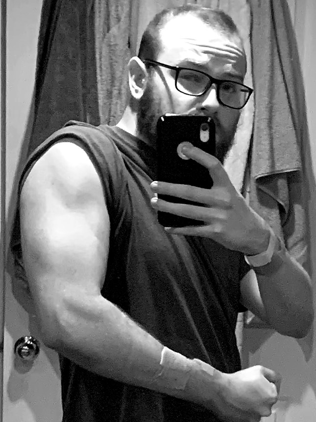 Miller flexing in a tank top with hospital wristbands still on