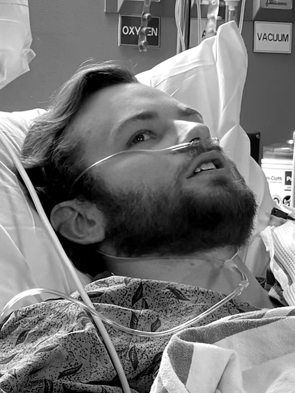 Miller in a hospital bed with an oxygen cannula